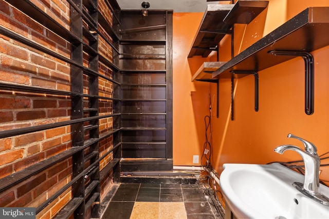 bathroom with brick wall and sink