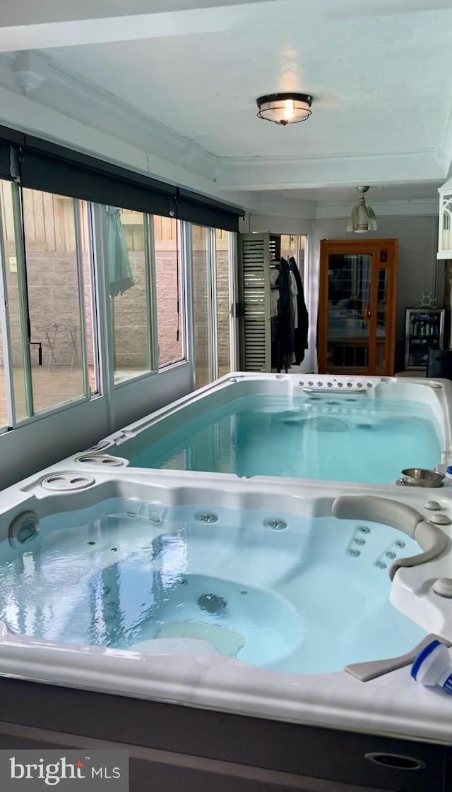 view of swimming pool with an indoor hot tub