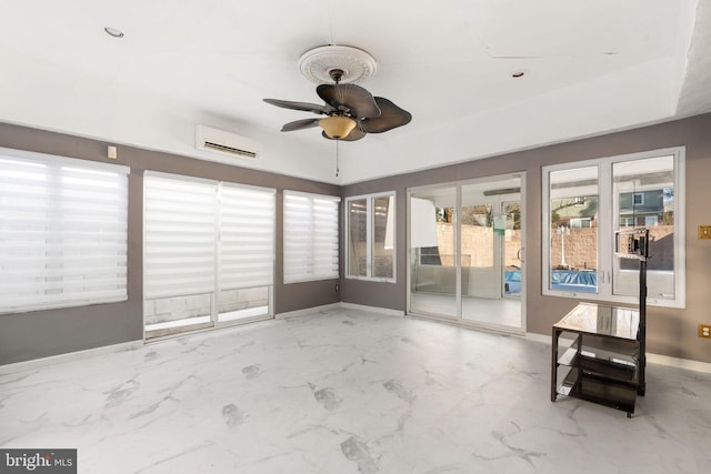 unfurnished sunroom featuring ceiling fan and an AC wall unit