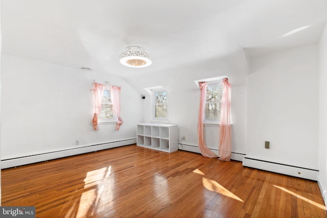 bonus room featuring a baseboard radiator, vaulted ceiling, and hardwood / wood-style floors