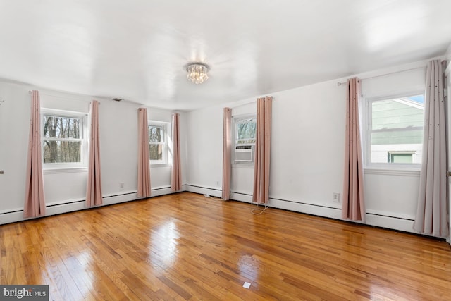 spare room with a wealth of natural light, light wood-type flooring, and cooling unit