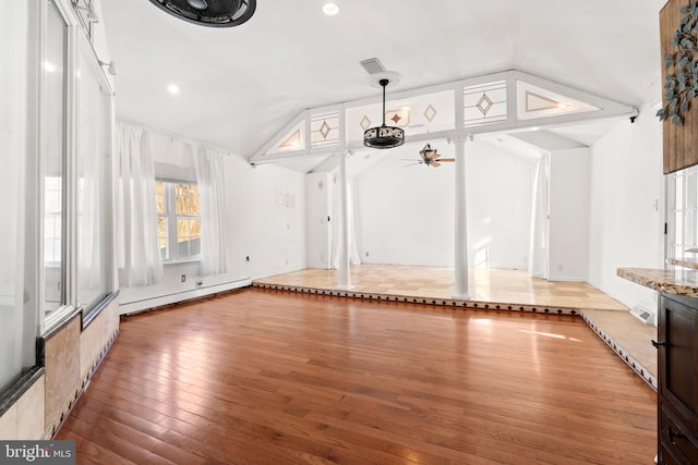 interior space with vaulted ceiling, ceiling fan, and baseboard heating