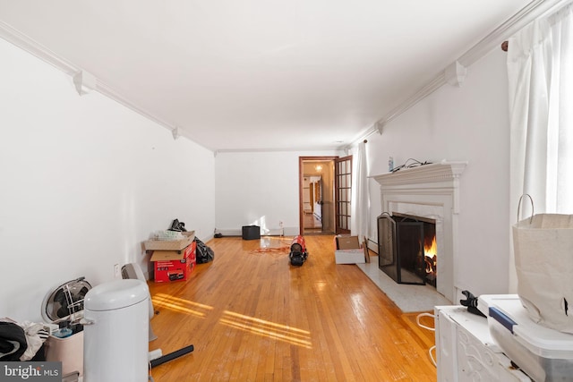 exercise room featuring hardwood / wood-style floors, a fireplace, and ornamental molding