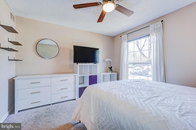 carpeted bedroom with a textured ceiling and ceiling fan