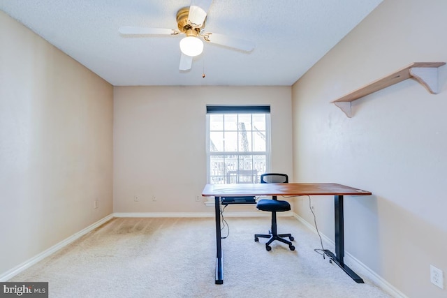 office space with light carpet, a textured ceiling, and ceiling fan