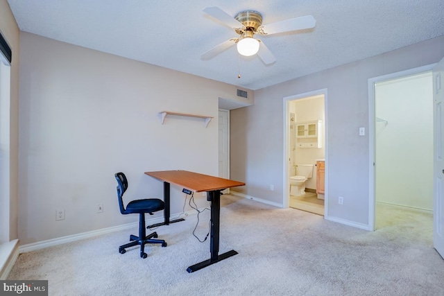 carpeted home office with ceiling fan and a textured ceiling