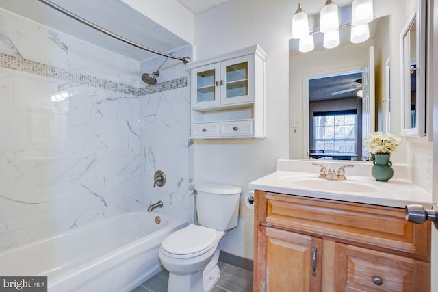 full bathroom featuring tiled shower / bath, vanity, ceiling fan, and toilet