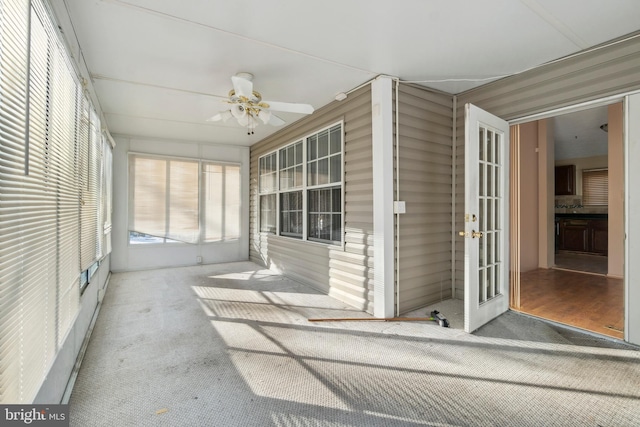 unfurnished sunroom with ceiling fan