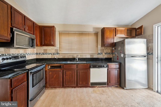 kitchen featuring sink, decorative backsplash, stainless steel appliances, and light wood-type flooring