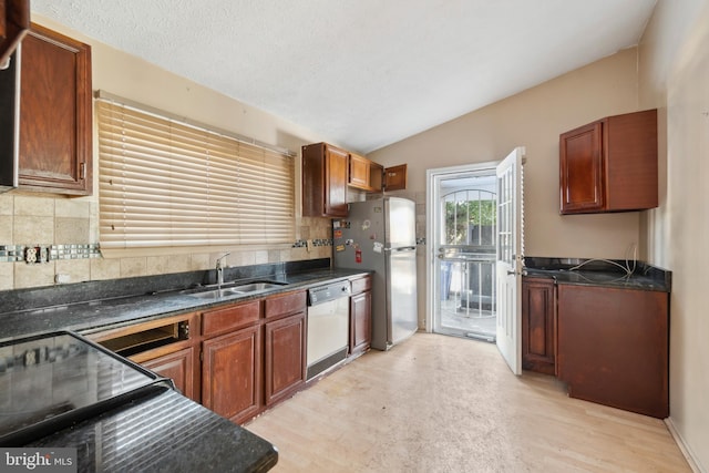 kitchen featuring lofted ceiling, sink, appliances with stainless steel finishes, light hardwood / wood-style floors, and decorative backsplash