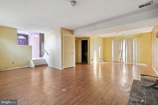 unfurnished living room with hardwood / wood-style floors and a textured ceiling