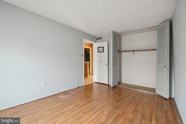 unfurnished bedroom with wood-type flooring and a closet