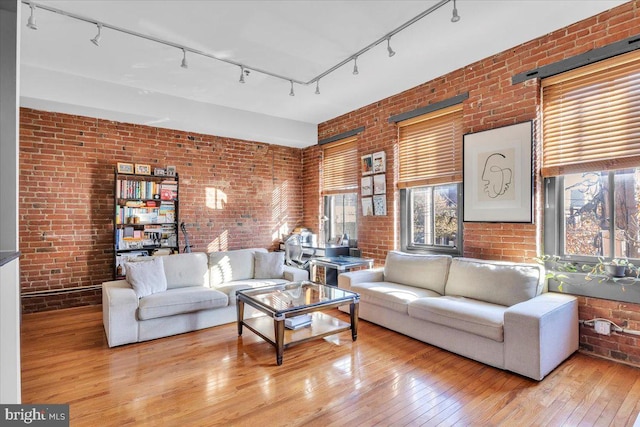 living room with light wood-type flooring and brick wall