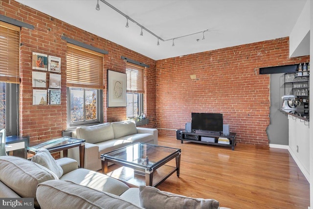 living room featuring brick wall and hardwood / wood-style floors