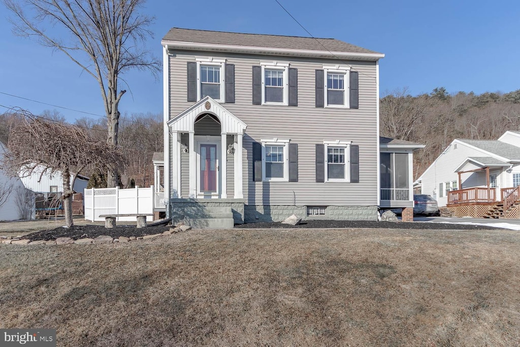 view of front of home with a front lawn and a sunroom