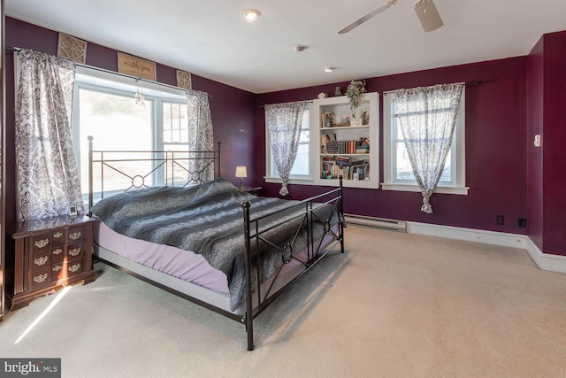 bedroom featuring ceiling fan, carpet flooring, multiple windows, and a baseboard heating unit