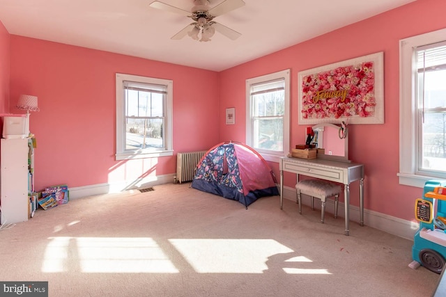 interior space featuring plenty of natural light, carpet flooring, and radiator