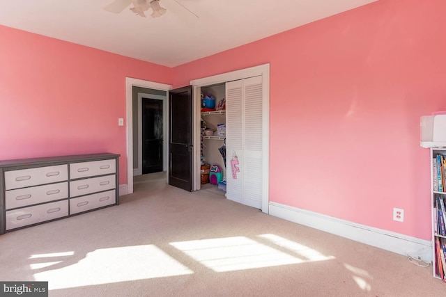 unfurnished bedroom with light carpet, a closet, and ceiling fan