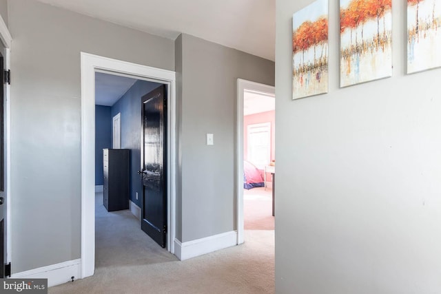 hallway featuring light colored carpet