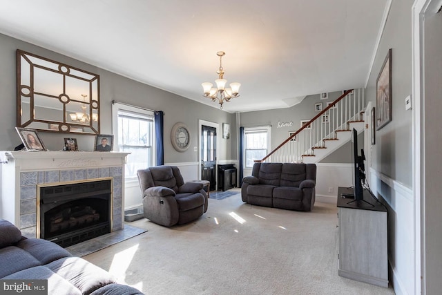 living room featuring light carpet, a tile fireplace, and a chandelier