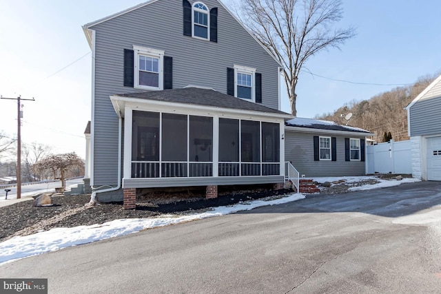 view of front of property with a garage and a sunroom