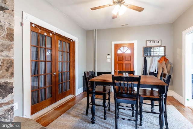 dining room with hardwood / wood-style flooring, a healthy amount of sunlight, ceiling fan, and french doors