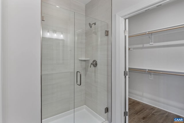 bathroom with an enclosed shower and hardwood / wood-style floors