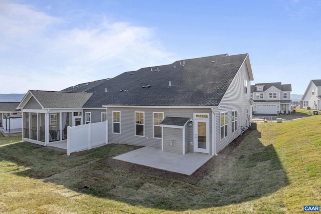 rear view of property with central AC unit, a patio area, a sunroom, and a lawn