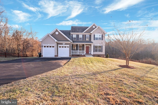 view of front of house with a porch, a garage, and a front lawn