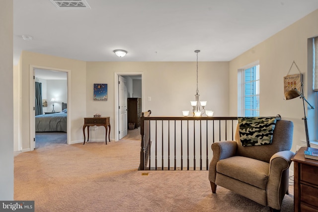 living area featuring light carpet and an inviting chandelier