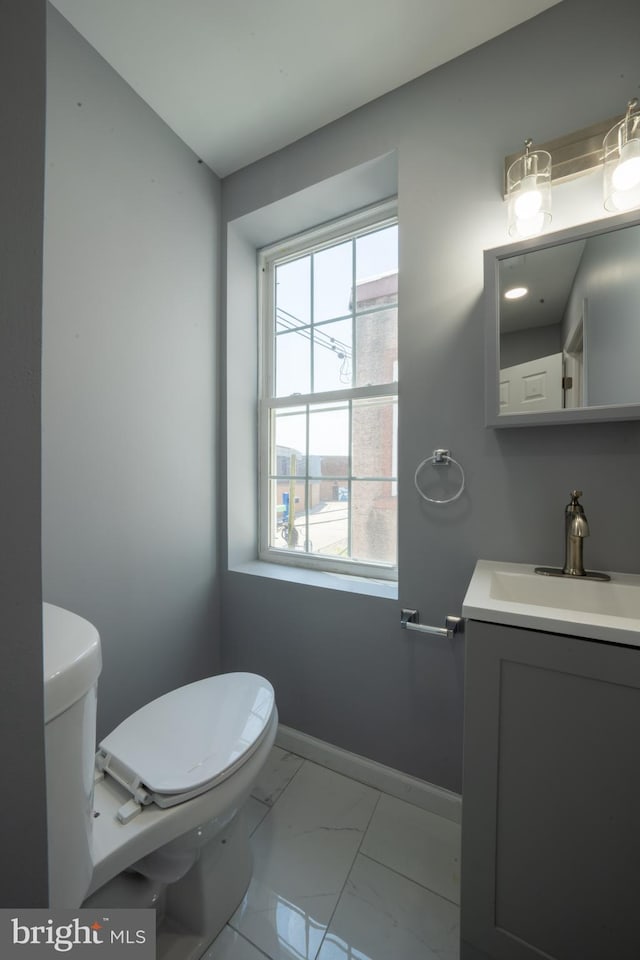 bathroom featuring vanity, plenty of natural light, and toilet