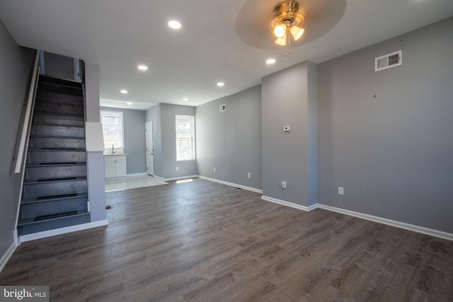 unfurnished living room featuring sink, dark wood-type flooring, and ceiling fan