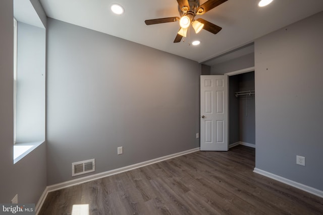 unfurnished bedroom featuring hardwood / wood-style flooring, ceiling fan, and a closet