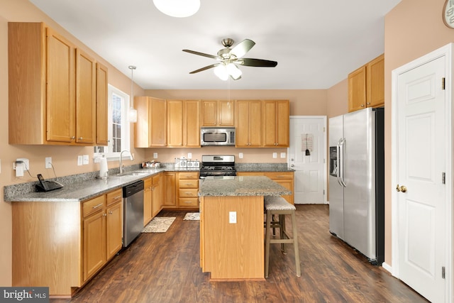 kitchen featuring a kitchen island, light stone countertops, appliances with stainless steel finishes, and a kitchen bar