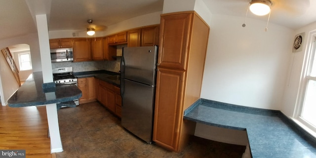 kitchen with stainless steel appliances, a wealth of natural light, ceiling fan, and decorative backsplash