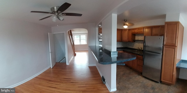 kitchen with stainless steel refrigerator, ceiling fan, sink, and tasteful backsplash