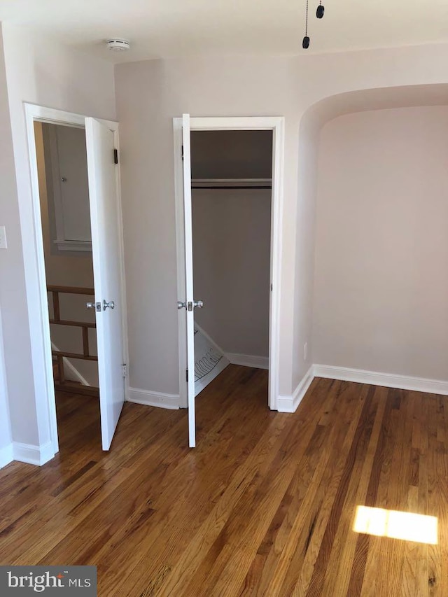 unfurnished bedroom featuring dark wood-type flooring and a closet