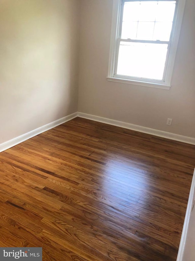 spare room featuring dark wood-type flooring