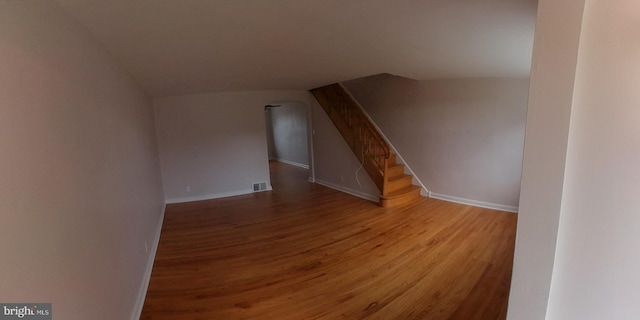 additional living space with hardwood / wood-style flooring