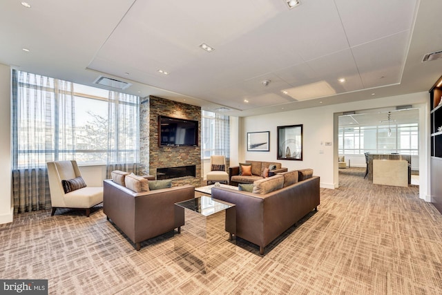 carpeted living room featuring a stone fireplace