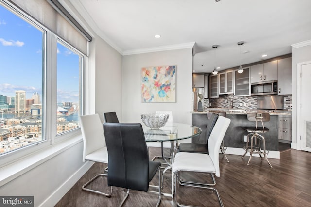 dining area with dark wood-type flooring and ornamental molding