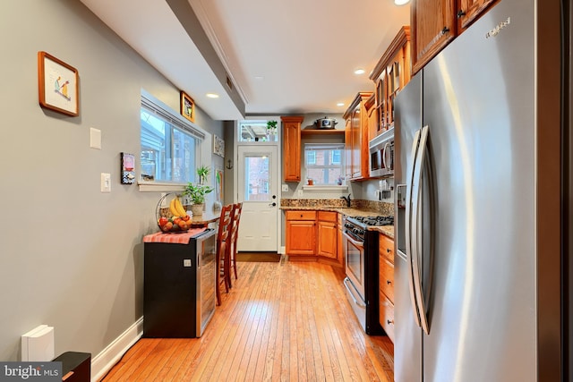 kitchen featuring stainless steel appliances, sink, light hardwood / wood-style flooring, and plenty of natural light