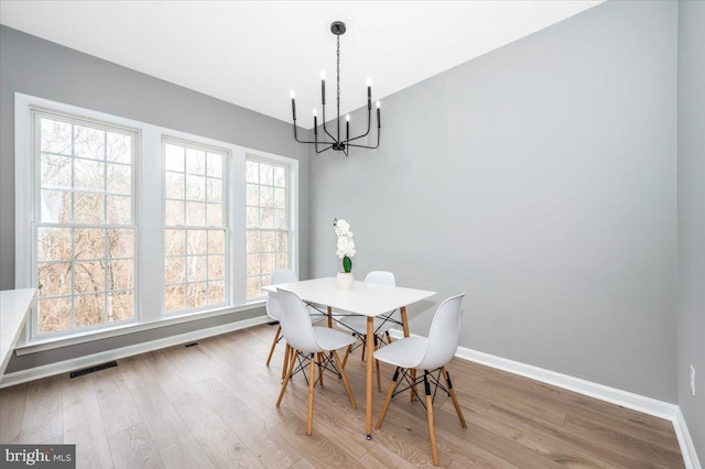 dining space with an inviting chandelier and hardwood / wood-style flooring