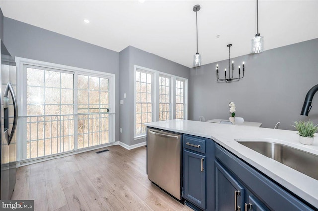 kitchen featuring sink, light hardwood / wood-style flooring, blue cabinetry, appliances with stainless steel finishes, and hanging light fixtures