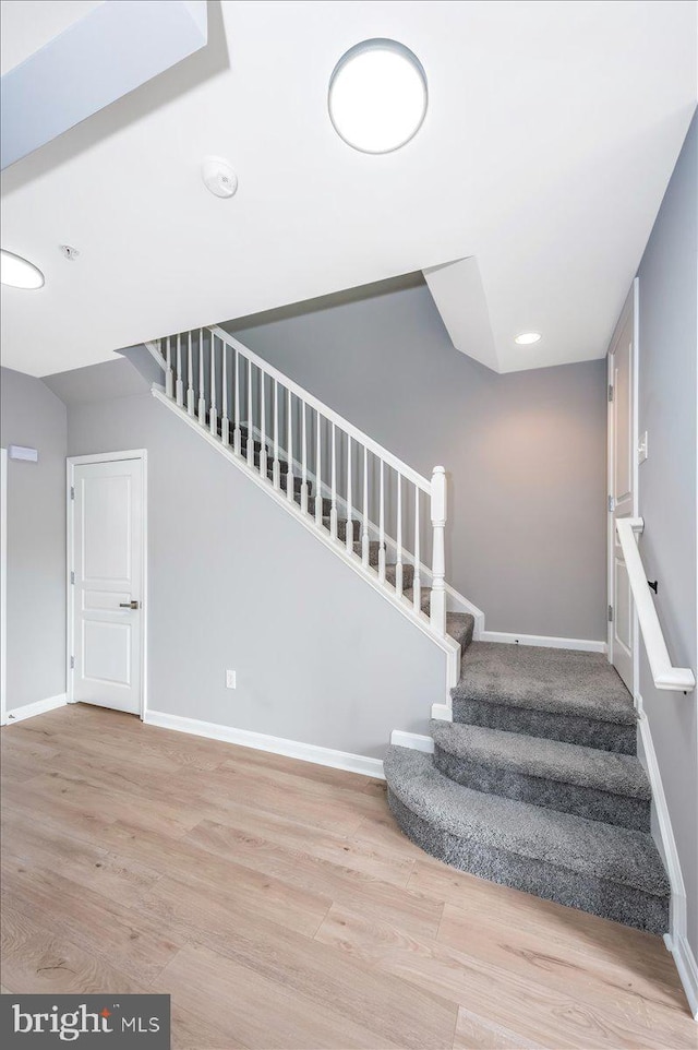 stairs featuring hardwood / wood-style floors