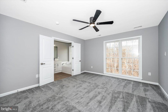 unfurnished bedroom with ceiling fan, ensuite bathroom, and carpet floors