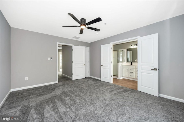 unfurnished bedroom featuring dark colored carpet, ceiling fan, and ensuite bath