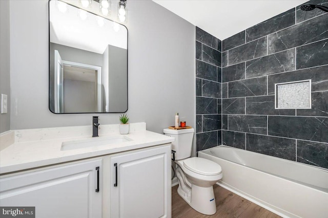 full bathroom with vanity, toilet, tiled shower / bath combo, and hardwood / wood-style floors