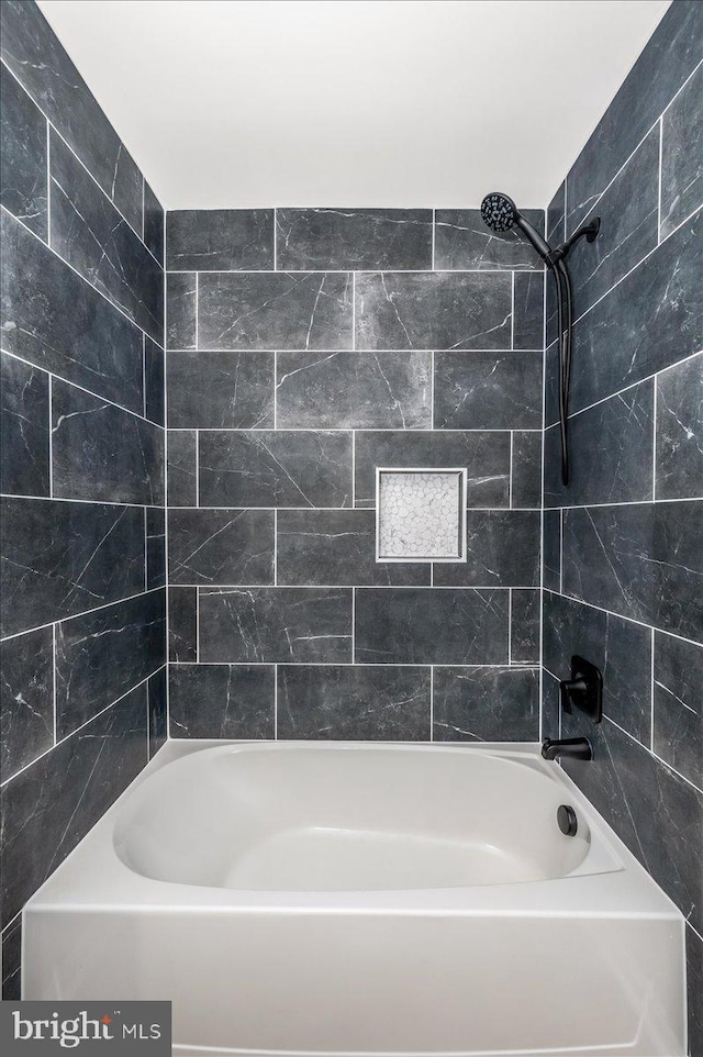 bathroom featuring tiled shower / bath