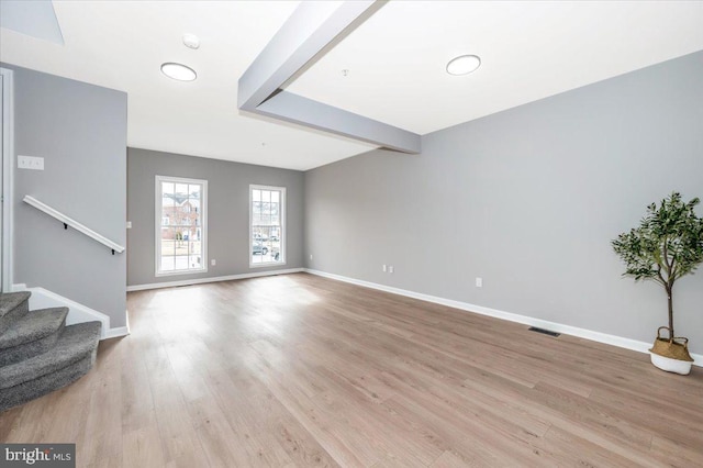 living room featuring beam ceiling and light hardwood / wood-style flooring